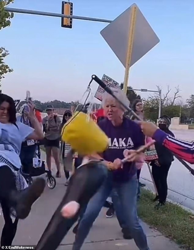 Protester wearing "Make America Kind Again" shirt smashes piñata of president