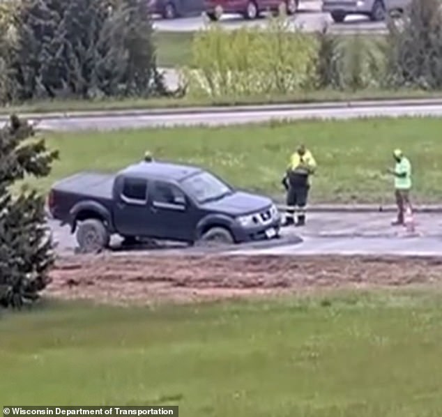 Wisconsin driver ignores road closure signs and drives into wet concrete.